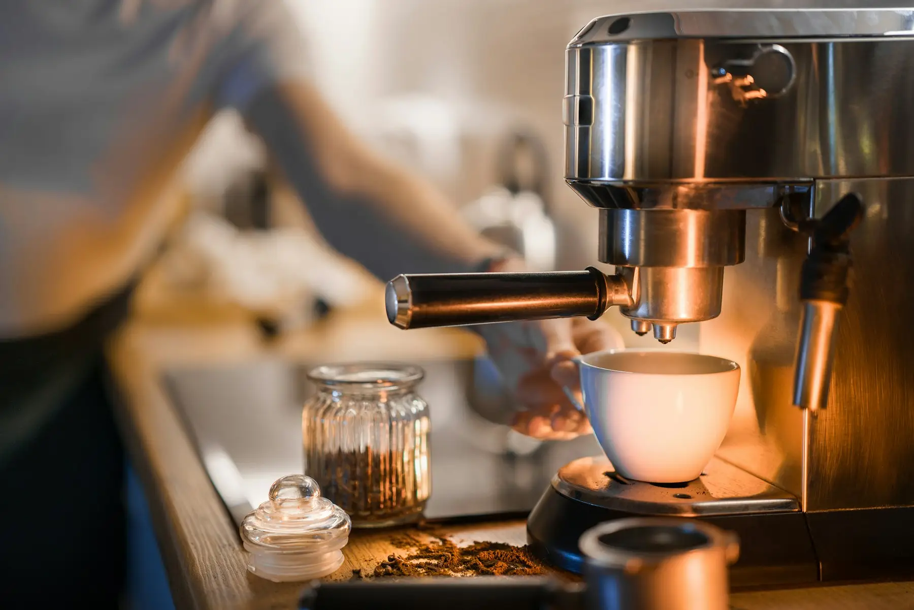 Espresso pouring from a coffee machine into a white cup